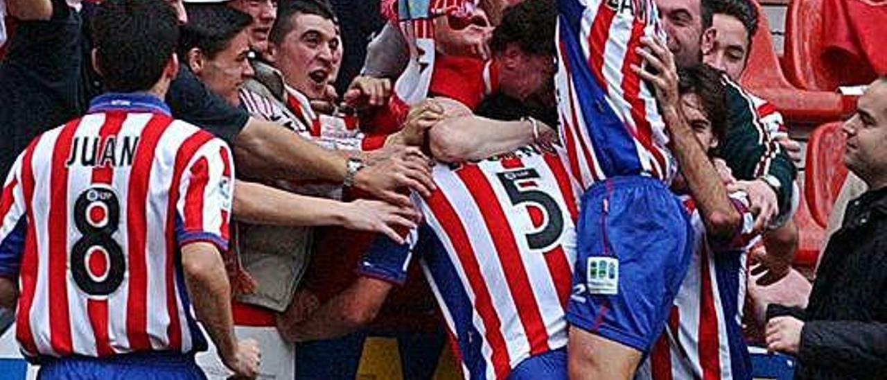 Lozano (número 5) y Villa celebran con aficionados el gol al Oviedo.