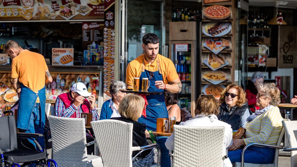 Un camarero atiende a los clientes en una terraza de Benidorm.