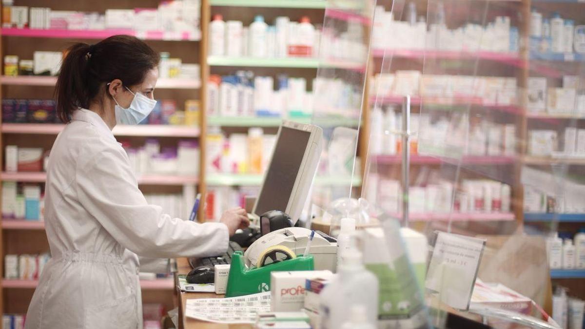 Una farmacéutica trabajando en una farmacia.