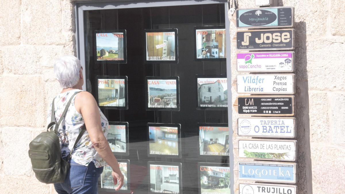 Imagen de archivo de una mujer viendo las ofertas de una inmobiliaria en Cangas.