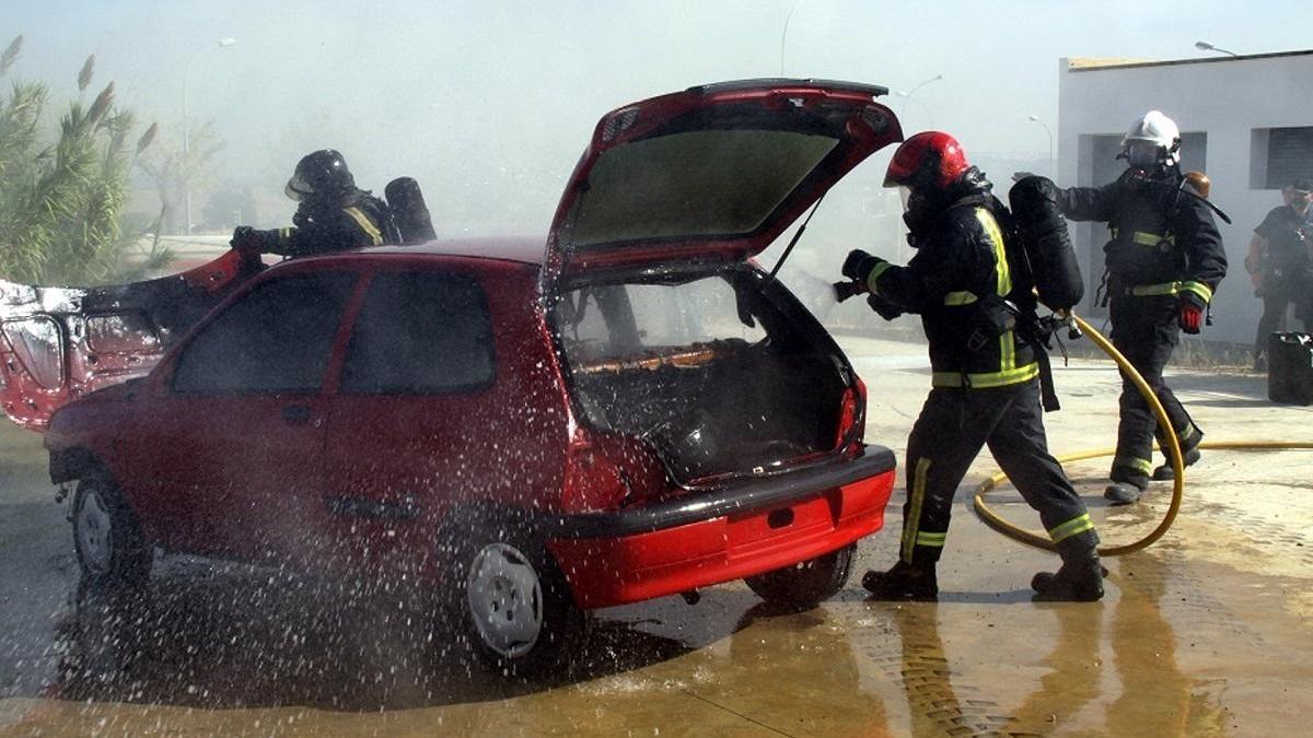 Bomberos actúan contra el fuego en un turismo, en una imagen de archivo.