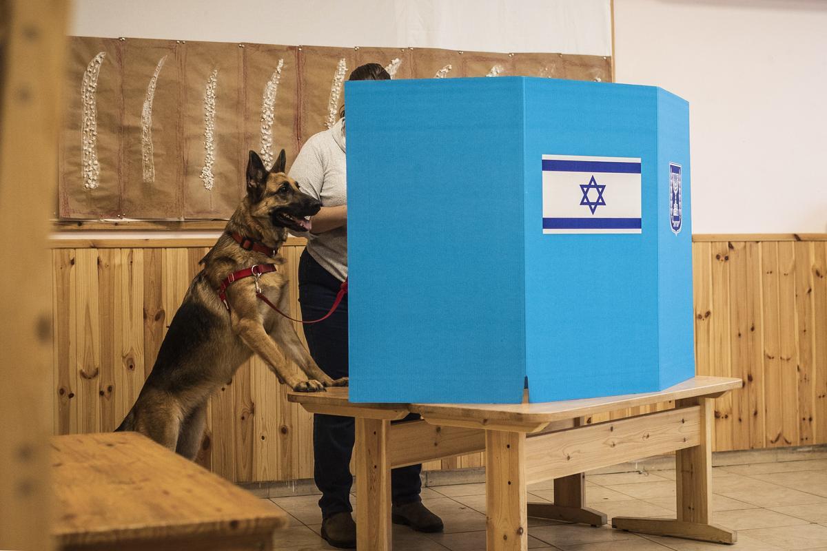 Hilit vota con su perro Democracia en un colegio electoral durante las elecciones generales israelíes de 2022.