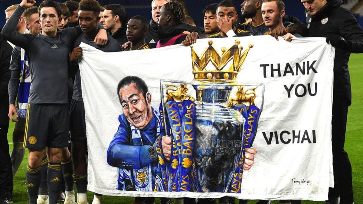 Los jugadores del Leicester City James Maddison (2R) y Demarai Grey (3L) sostienen una pancarta que muestra al presidente, Vichai Srivaddhanaprabha, después del partido de fútbol de la Premier League inglesa entre Cardiff City y Leicester City.