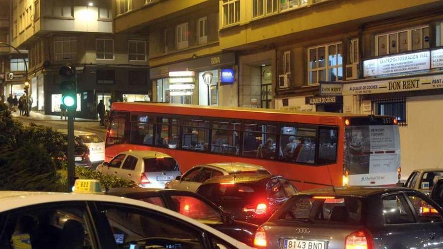 Un taxi, un autobús y vehículos privados, en la glorieta de las estaciones.