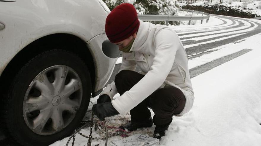 Colocando cadenas en la carretera tras una fuerte nevada.