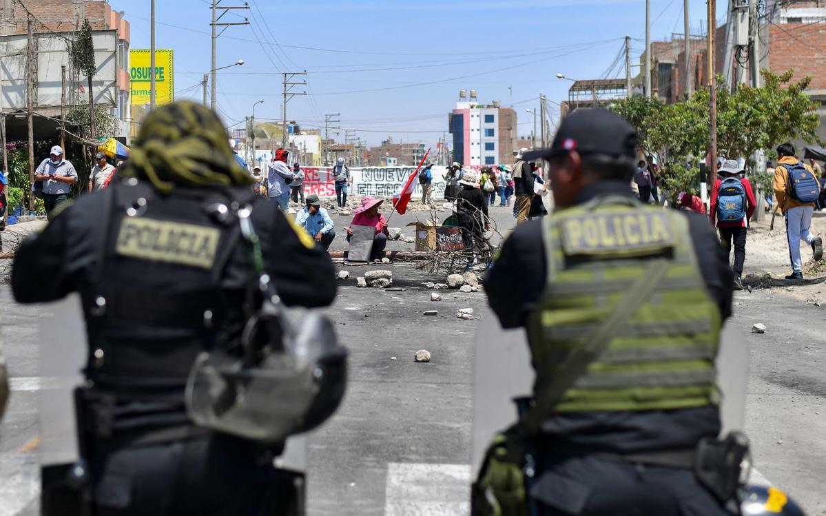 Policía antidisturbios frente a los manifestantes que bloquean la carretera Panamericana exigiendo la renuncia de la presidenta de Perú, Dina Boluarte