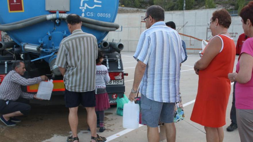 Veïns fan cua per omplir garrafes d&#039;aigua en un dels camions cisterna.