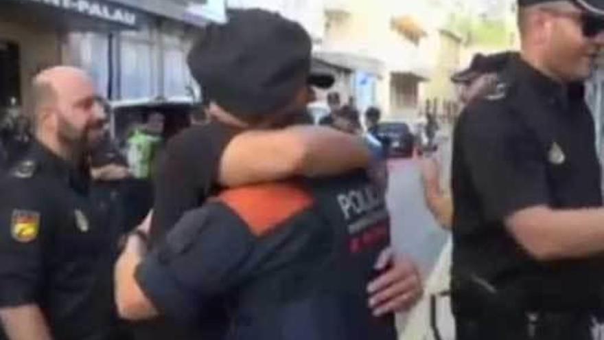 Abrazo entre un policía nacional y un mosso.