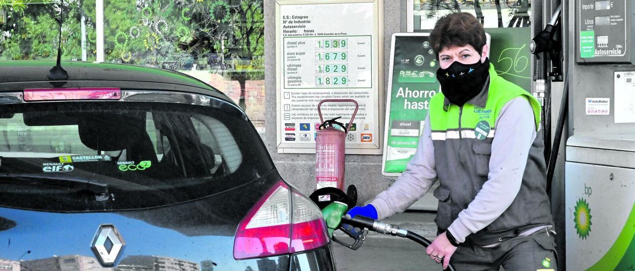 Una empleada de una estación de servicio de la ciudad de Castelló llena el depósito de combustible un vehículo.