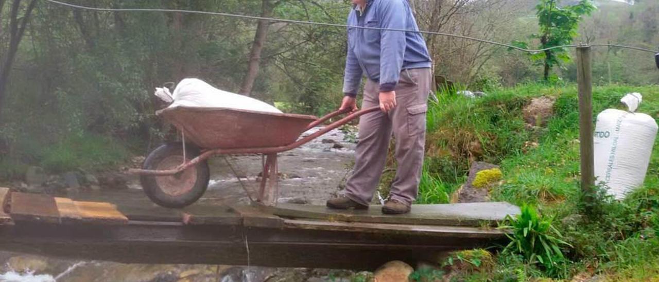 Jesús Riestra pasa por el improvisado puente.