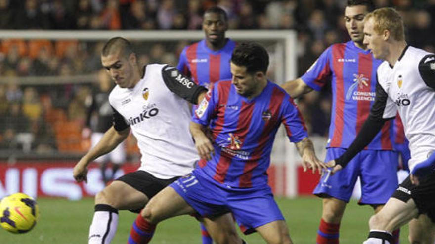 Jugadores del Valencia y del Levante pugnan por un balón.