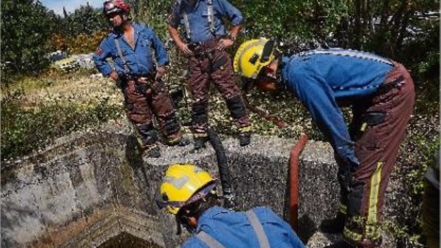 Els bombers treballant en el drenatge del rec, a tocar d&#039;on va aparèixer el cadàver.