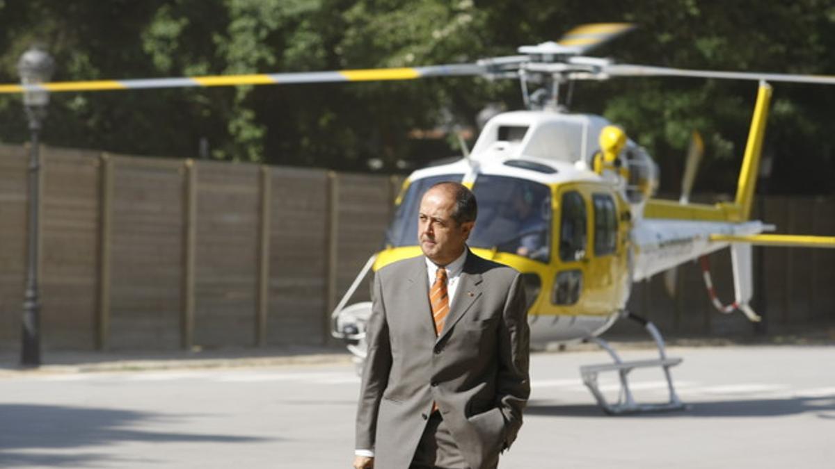 El 'conseller' de Interior, Felip Puig, a su llegada al Parlament, con el helicóptero al fondo.
