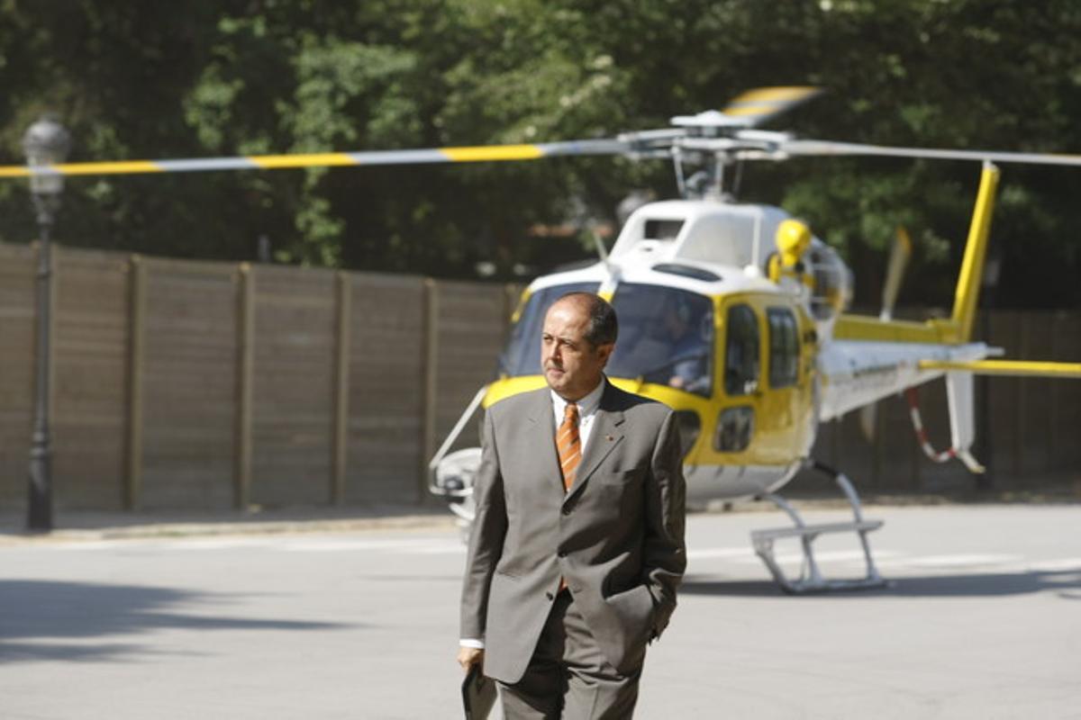 El conseller d’Interior, Felip Puig, a l’arribar al Parlament, amb l’helicòpter al fons.