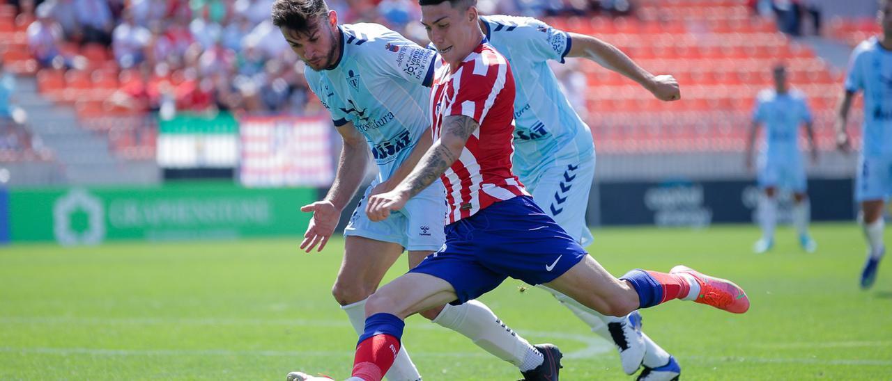 Dos jugadores del Don Benito presionan a un futbolista del Atlético B.