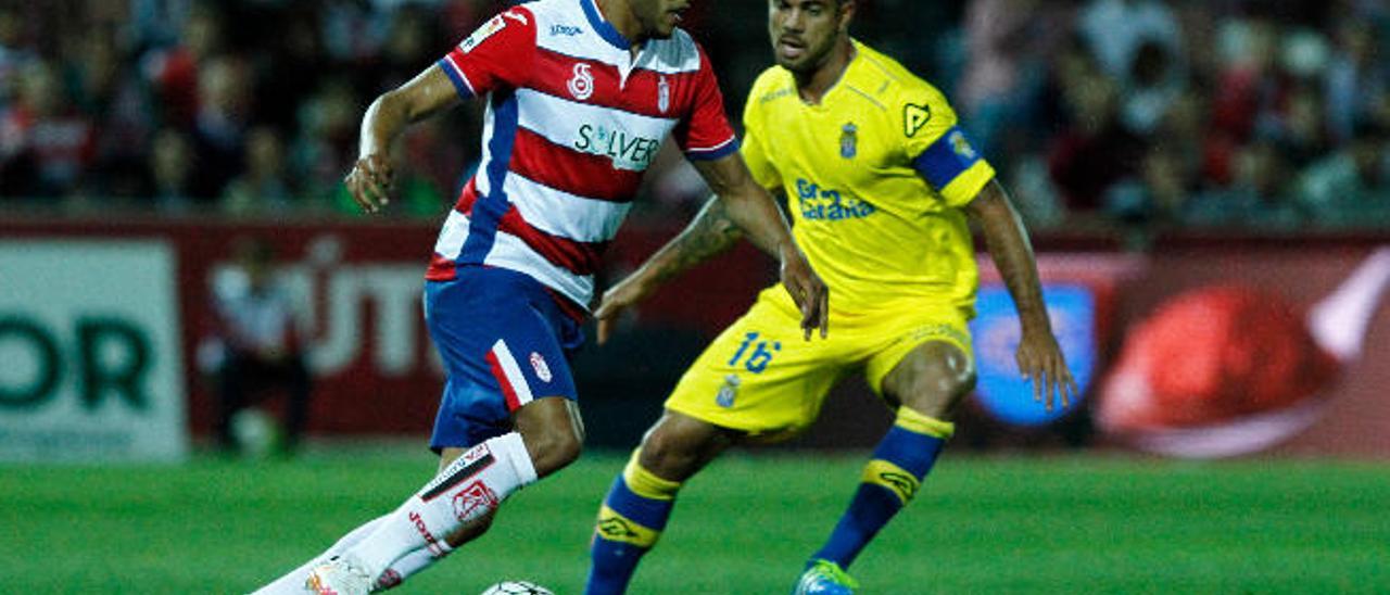 El Arabi conduce el balón ante la presión de Aythami Artiles durante el partido de ayer en el Nuevo Los Cármenes.