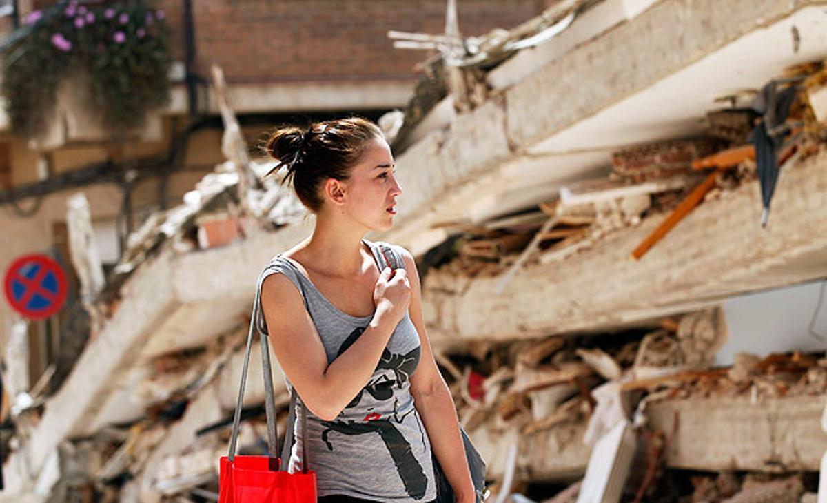 Una noia passa prop d’un edifici derruït després del terratrèmol a Llorca.
