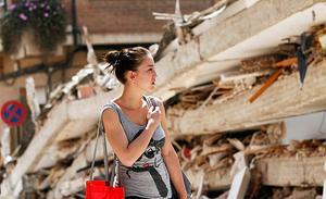 Una noia passa prop d’un edifici derruït després del terratrèmol a Llorca.