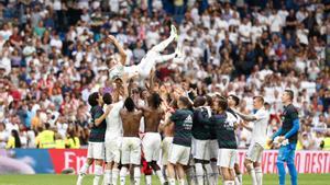 Karim Benzema es manteado por sus compañeros al final del partido. 