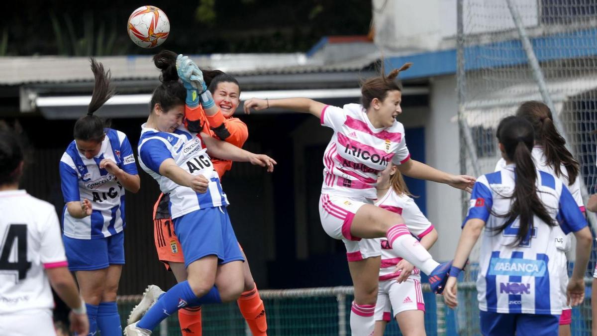 La portera del Oviedo despeja ante el intento de remate de dos jugadoras del Sárdoma. // JOSÉ LORES