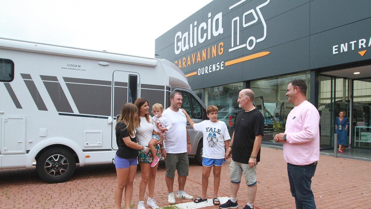 La familia de Xavi y Mar con Salva, el jefe de taller y Anxo, responsable, tras arreglar su autocaravana.
