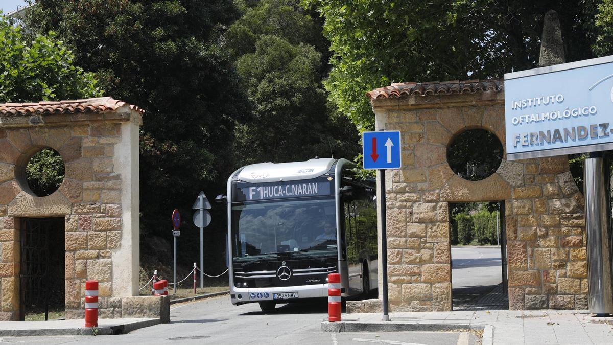 Un autobús eléctrico sale del recinto del Hospital Monte Naranco, con la portada de piedra ya sin el arco.