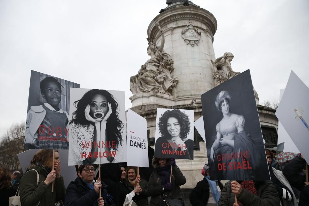 Varias activistas sujetan pancartas con rostros de mujeres famosas en la Plaza de la Reppública en París. / AFP PHOTO / GEOFFROY VAN DER HASSELT