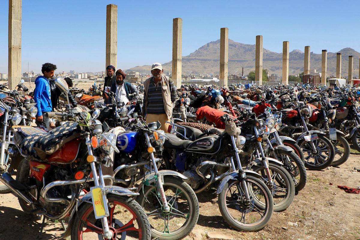 Los yemeníes se reúnen en medio de motocicletas mientras esperan que se les expidan licencias para conducir como parte de una campaña de seguridad de las autoridades huzíes, en Yemen