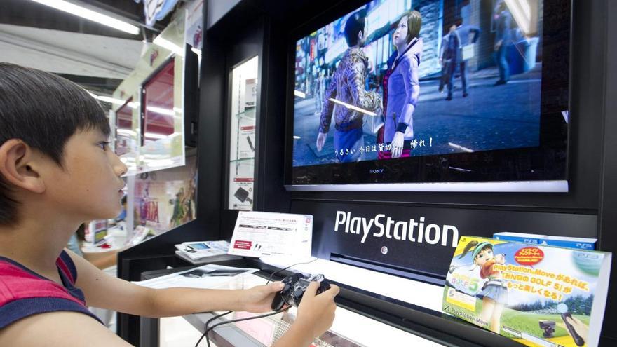 Un menor juega con una consola PlayStation.