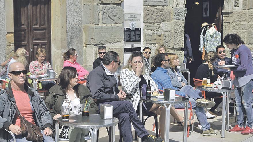 Turistas, en una terraza en Gijón.