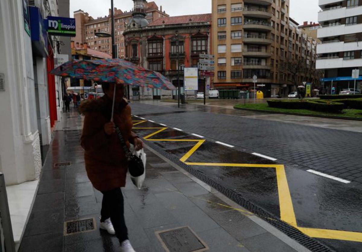 A la izquierda, el nuevo pavimento de hormigón impreso extendido en la plaza La Merced, con la actual campa de la iglesia –a la derecha– cuya reforma se espera hacer este año; a la derecha, Manuel Martino, jefe de obra de CGS, con el concejal Pelayo García, junto a la lámina de agua instalada en la plaza como decoración. | Mara Villamuza