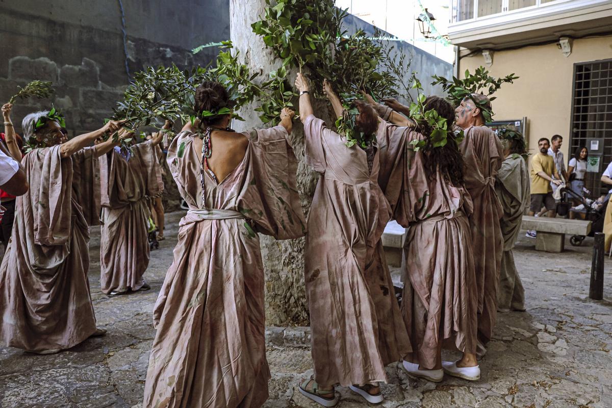Vecinos de la Calatrava y Canamunt, muchos vestidos de verde y con ramas de árboles, se unen durante sus cercavilas para homenajear a los bellasombras talados en la plaza Llorenç Villalonga.