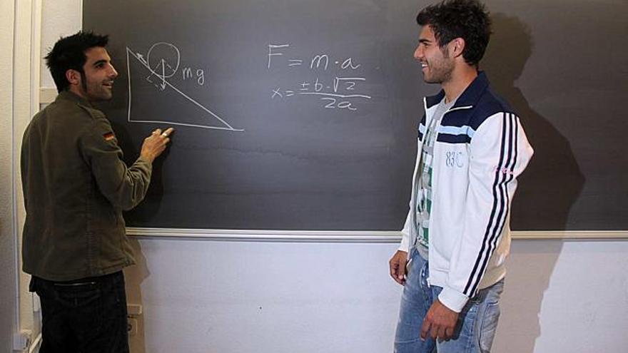 Del Olmo y Jorge Alonso repasan una fórmula matemática en un aula de la Universidad de Alicante