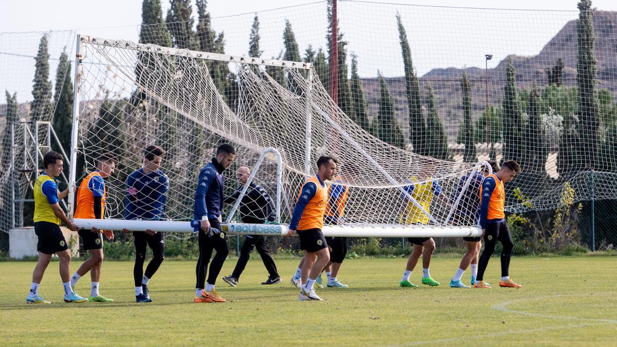 Los jugadores del Hércules cargan con una portería para realizar un ejercicio en Fontcalent.