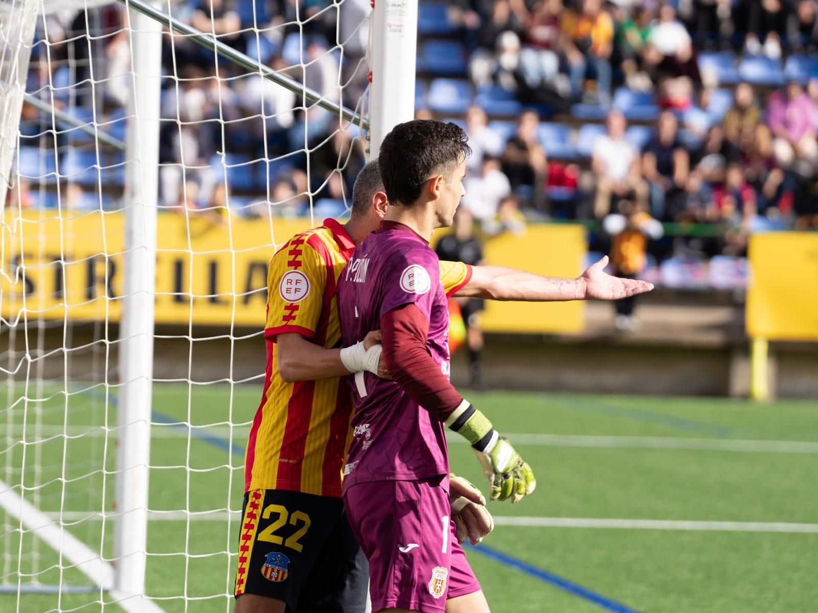 Un jugador de la UE Sant Andreu intenta alejar a Picón de la grada desde dónde es insultado y escupido