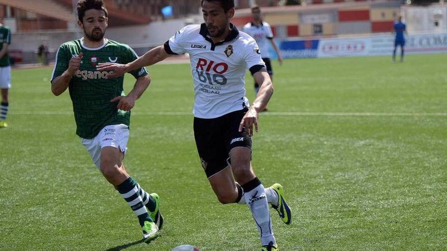 Noel Alonso conduce el balón ante Jorge Rodríguez en el Caudal-Racing de Ferrol de la temporada 2013-14.