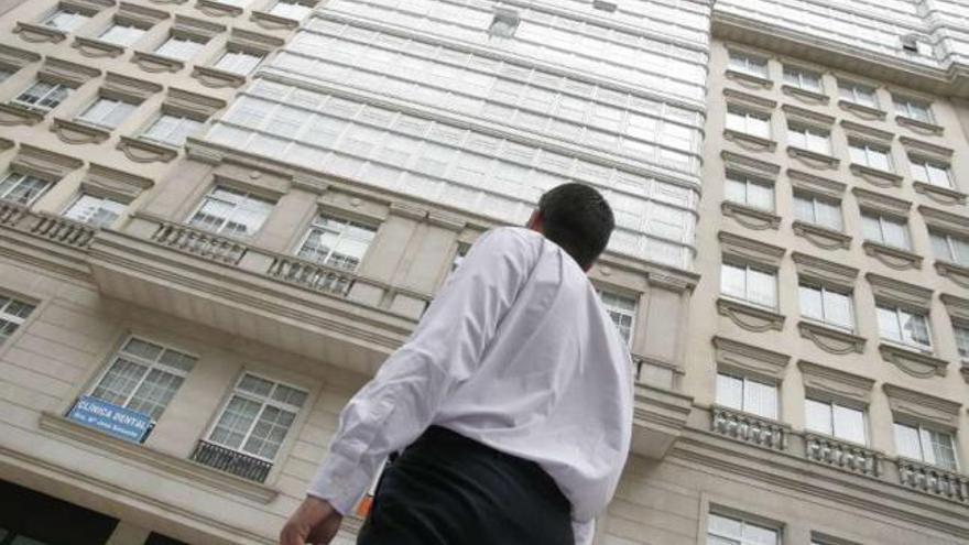 Un hombre pasa frente a la fachada del edificio Conde de Fenosa. / eduardo vicente