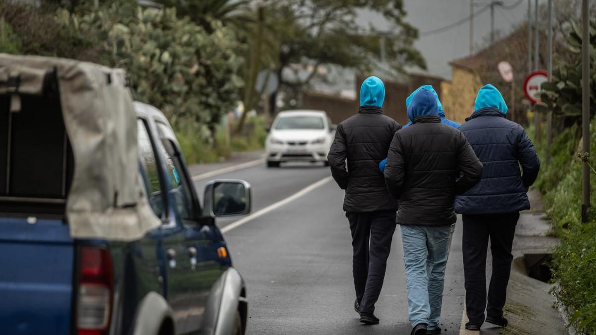 Inmigrantes caminan por la carretera en dirección a La Laguna