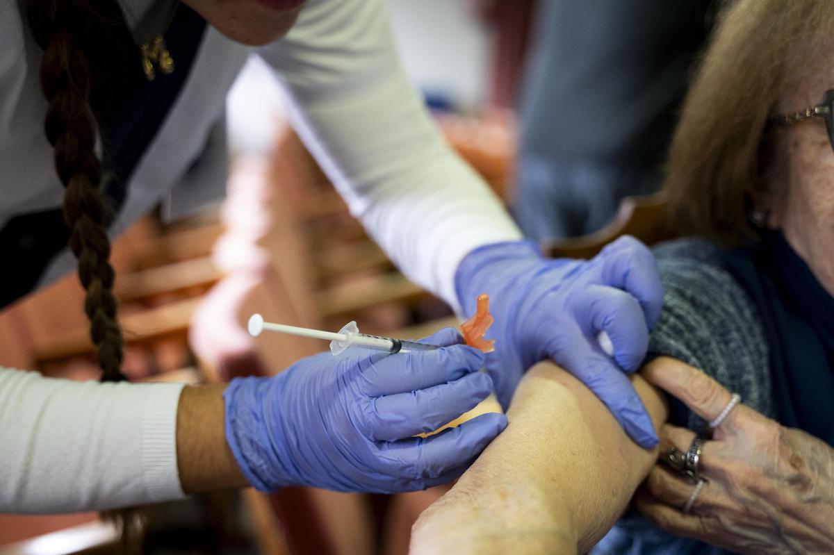 Una enfermera vacuna a una mujer.
