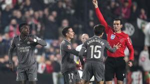 Referee Juan Martinez Munuera shows a yellow card to Real Madrids Vinicius Junior, left, during the Spanish La Liga soccer match between Rayo Vallecano and Real Madrid at the Vallecas stadium in Madrid, Spain, Saturday, Dec. 14, 2024. (AP Photo/Manu Fernandez)
