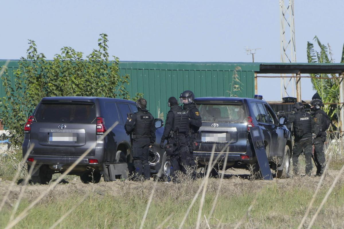 Agentes de policía desplegados frente a la nave en la que se encuentra atrincherado en Isla Mayor (Sevilla). El policía nacional herido de gravedad por un disparo se encuentra “grave, pero estable”, tras ser operado de urgencia en el hospital Virgen del Rocío de Sevilla. El policía participaba en una operación de vigilancia de lucha contra el narcotráfico a través del río Guadalquivir y ha resultado herido en un tiroteo durante el asalto a una 'guardería de la droga' en dicha localidad. EFE/ David Arjona. sustituye info