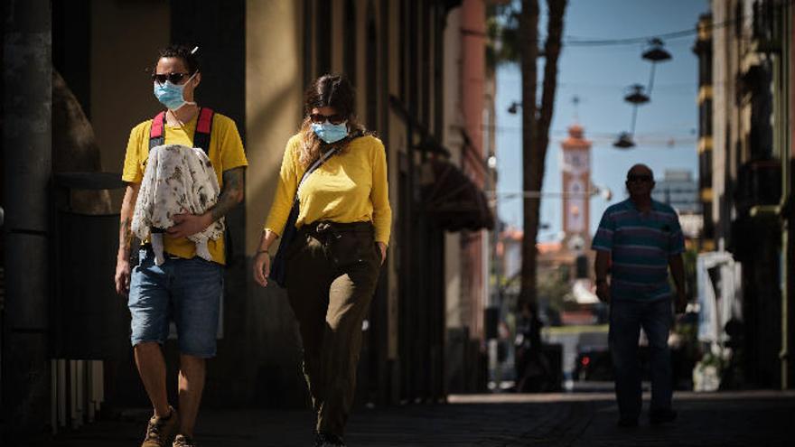 Una familia pasea por el centro de Santa Cruz con sus mascarillas.