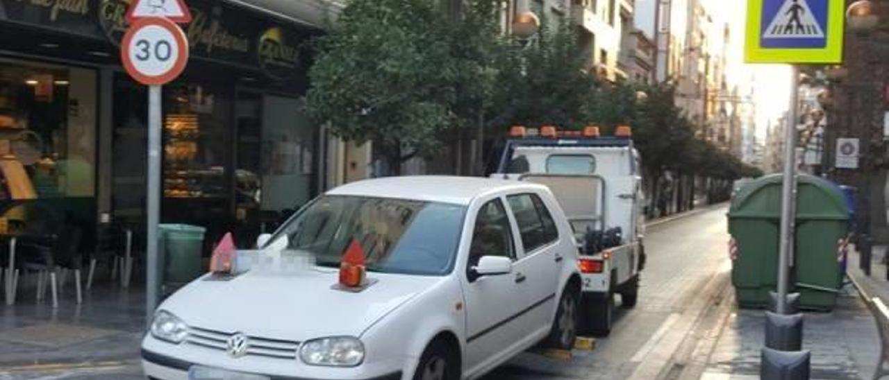 La grúa municipal retira un vehículo mal estacionado en Sagunt.