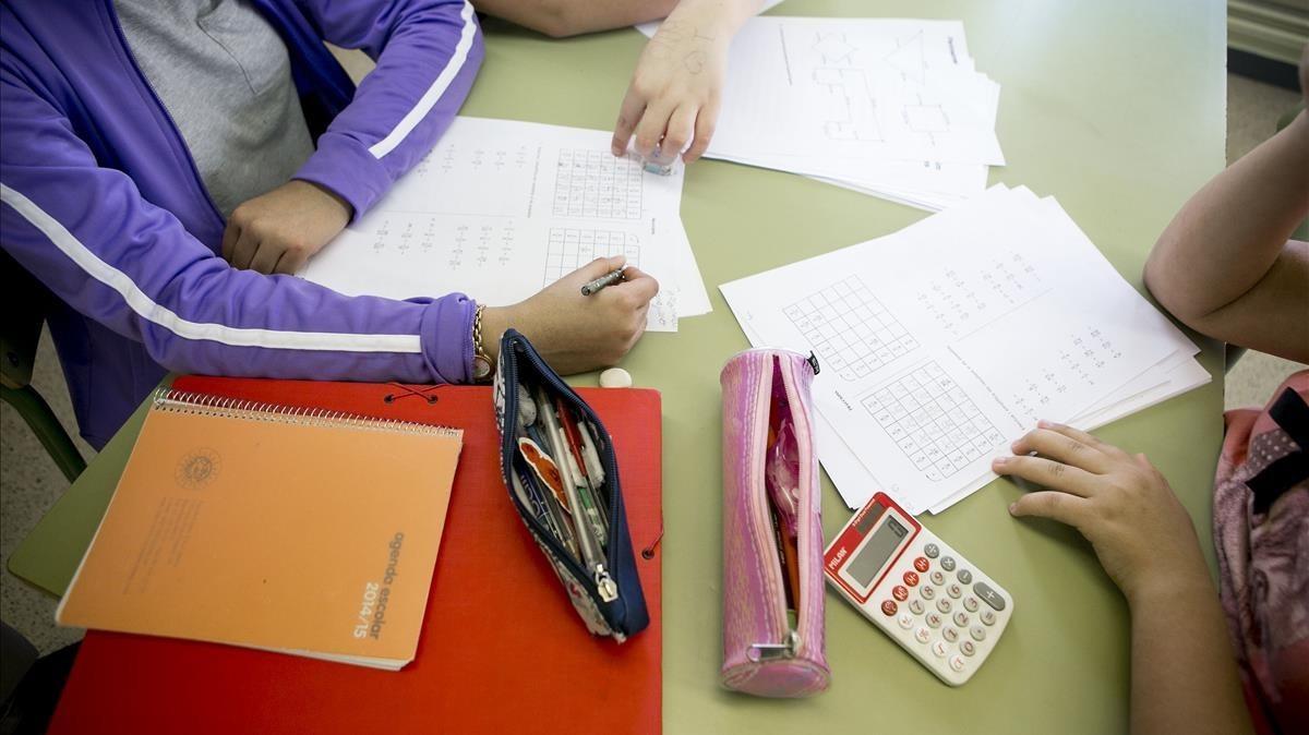 Unos estudiantes hacen deberes en la biblioteca de su colegio.