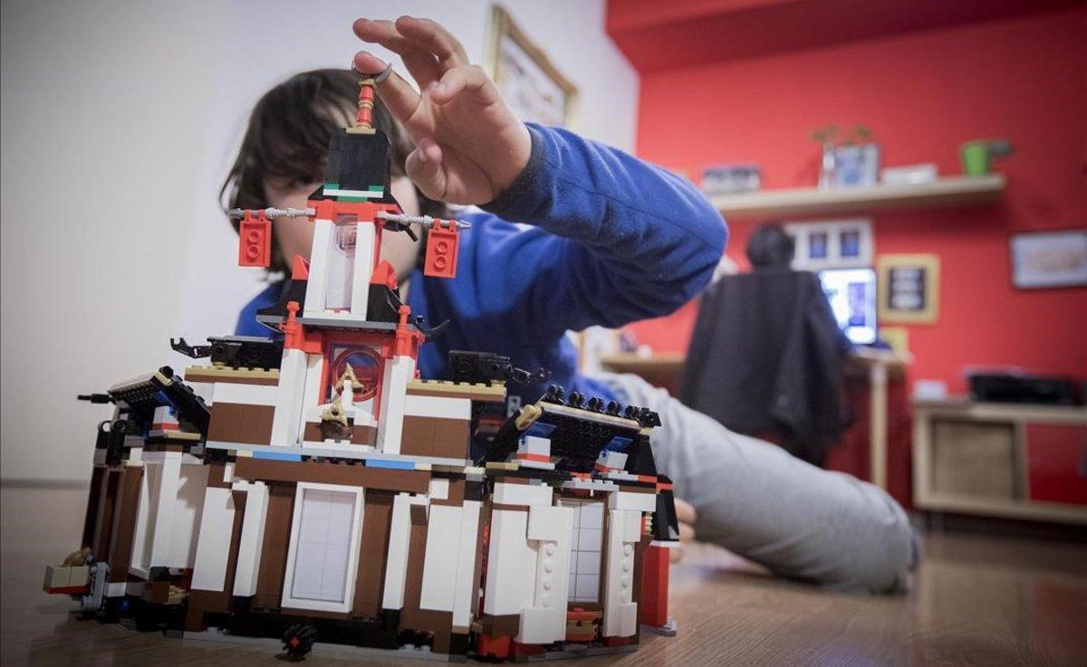 Un niño haciendo una construcción en el salón de su casa.