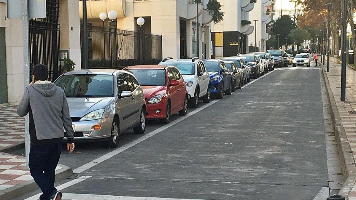 Un joven cruza la calle que circunda la urbanización La Zambomba, en el centro de Marbella.