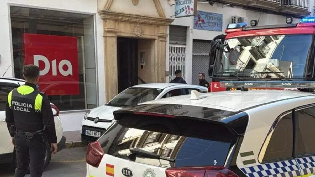 Bomberos y policía local, junto al inmueble donde se ha registrado el incendio.