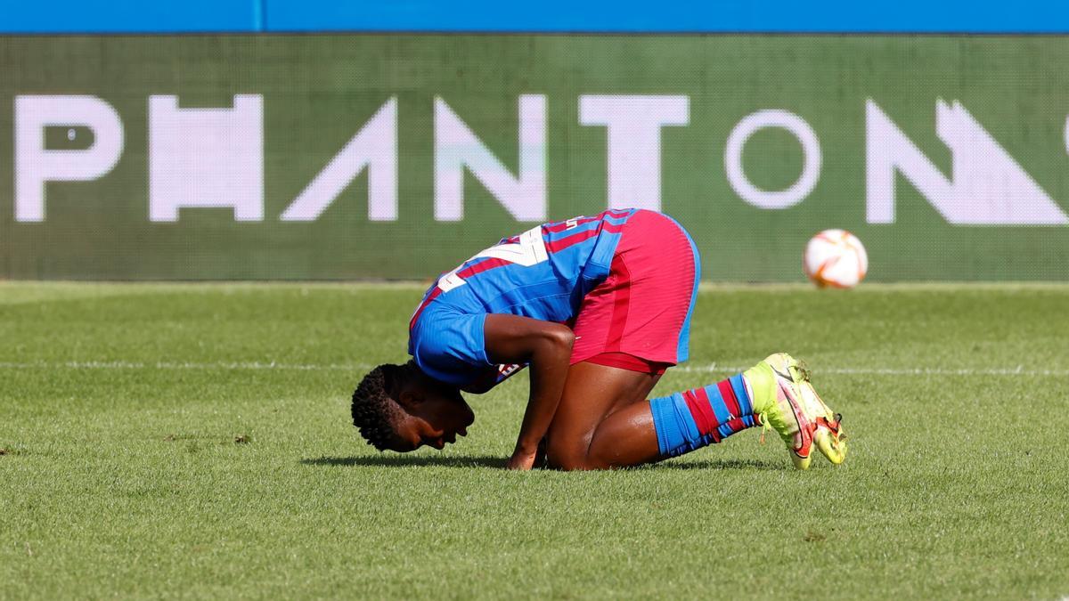 Oshoala besa la gespa de l&#039;Estadi Johan Cruyff després de marcar un dels dos gols que li va fer a la Reial Societat