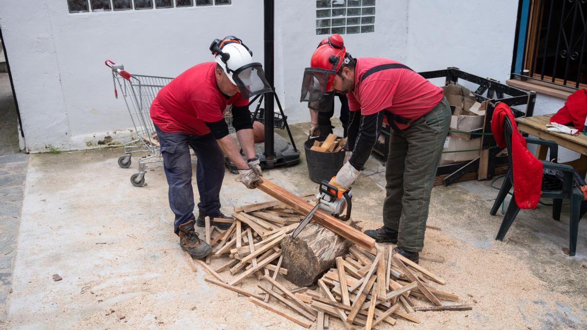 Operarios municipales cortan leña en el albergue de Torrechiva.