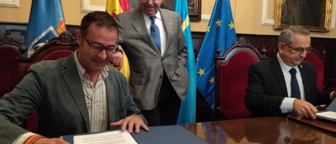 José Luis Costillas (a la izquierda) y el alcalde de La Unión, Pedro López Milán, firman el acuerdo de colaboración entre el Festival del Cante de las Minas y el Concurso de Tonada, ante la mirada del alcalde Canteli.